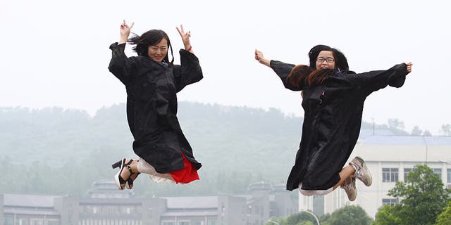 Femle students pose for graduating photograph at a university in Xiangyang, Hubei province, China on June 3, 2015.