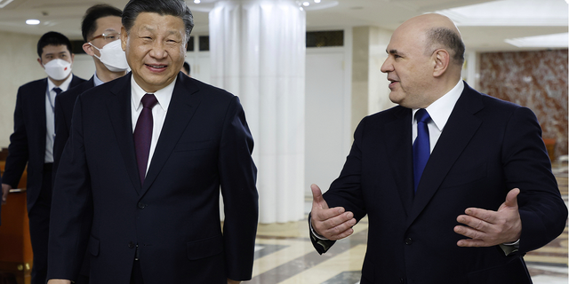 Russian Prime Minister Mikhail Mishustin, right, speaks with Chinese President Xi Jinping during their meeting in Moscow on Tuesday, March 21.