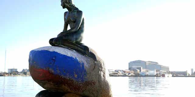 The Russian flag is painted on the stone where the Little Mermaid sits after the statue was vandalized in Copenhagen, Denmark, on March 2, 2023. 