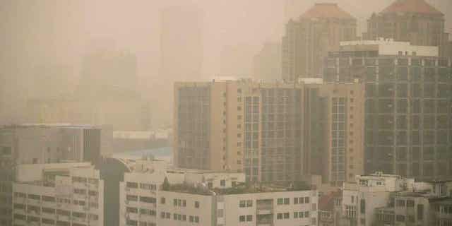 Haze and dust envelops buildings in Beijing on March 10, 2023. Air quality in the capital city plummeted because of dust storms and air pollution.