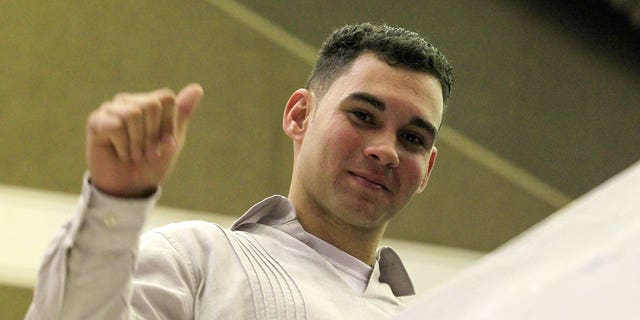 Cuba's shipwreck survivor Elian Gonzalez gestures after a speech by Cuba's President Raul Castro at the National Assembly in Havana, Dec. 20, 2014. Stepping out of his legendary brother's shadow, President Raul Castro has scored a diplomatic triumph and a surge in popular support with the deal that ends decades of open hostility with the United States.