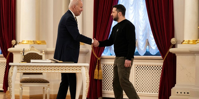 Ukraine's President Volodymyr Zelenskiy, right, and President Biden shake hands at Mariinsky Palace on an unannounced visit, in Kyiv, Ukraine, Feb. 20, 2023.