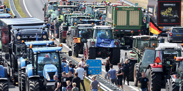 Farmers gather with their vehicles next to a Netherlands/Germany border sign on the A1 Highway, near Rijssen on June 29, 2022, during a protest against the Dutch Government's nitrogen plans, 