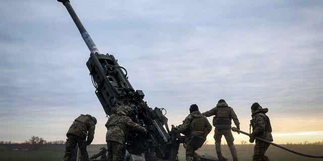 Ukrainian soldiers prepare a U.S.-supplied M777 howitzer to fire at Russian positions in Ukraine on Jan. 9, 2023. European Union officials are trying to speed up the delivery of Howitzer ammunition rounds to Ukraine.