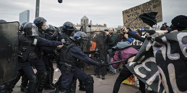 Protesters clash with French police officers during a demonstration in Lyon on Thursday. More than 400 officers were injured Thursday in protests against President Emmanuel Macron's pension reform, officials say.