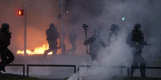 Riot polices scuffle with protesters on the sideline of a rally in Strasbourg, eastern France, Thursday, march 23, 2023. French unions are holding their first mass demonstrations Thursday since President Emmanuel Macron enflamed public anger by forcing a higher retirement age through parliament without a vote.