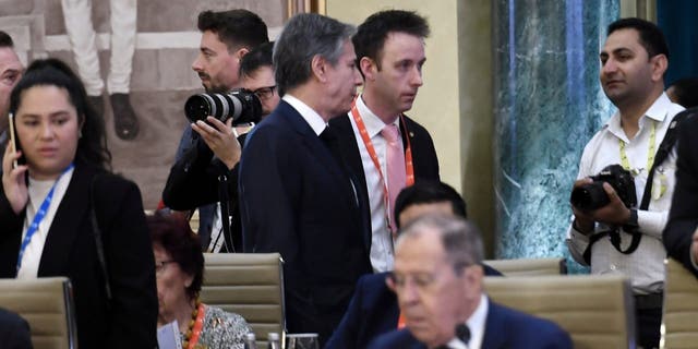 Secretary of State Antony Blinken, top center, walks past Russian Foreign Minister Sergey Lavrov during the G20 foreign ministers' meeting in New Delhi Thursday, March 2, 2023. 