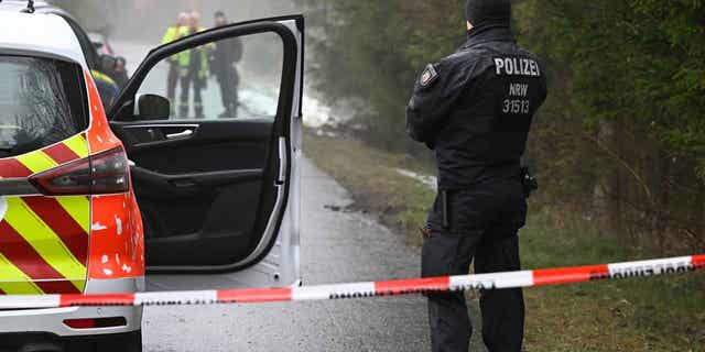 Police forces stand at a blocked off area in Freudenberg, Germany, on March 12, 2023. A girl went missing on Saturday and the police discovered her body on Sunday. Police have taken two children into custody in connection with the homicide.
