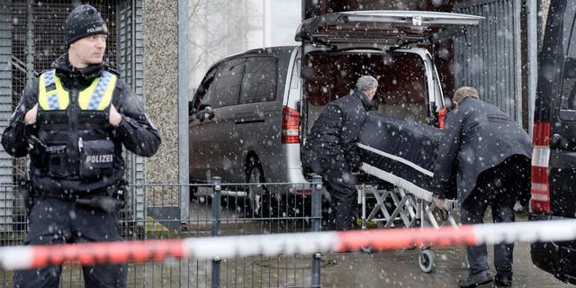 Corpses are carried out of a Jehovah's Witness building and loaded into hearses in Hamburg, Germany Friday, March 10, 2023. 