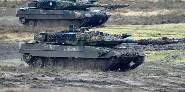 Two Leopard 2 tanks are seen in action in Augustdorf, Germany, on Feb. 1, 2023. Germany wants to buy back mothballed Leopard 2 tanks from Switzerland to replace tanks that the country is sending to Ukraine.