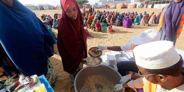 Food is prepared for people at a camp on the outskirts of Mogadishu, Somalia, on March 24, 2023. This year's holy month of Ramadan coincides with the longest drought on record in Somalia. 