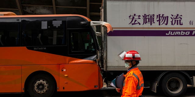 An ambulance worker inspects after an accident on a highway in Hong Kong, on March 24, 2023.