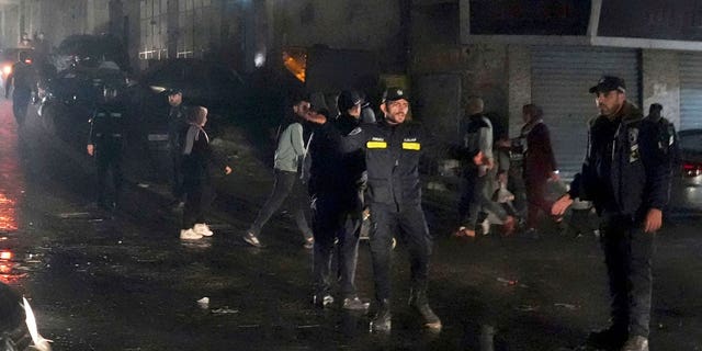 Hamas police officers secure the scene of a burned apartment on the third floor of a three-story building in Jebaliya refugee camp, northern Gaza Strip, Nov. 17, 2022.