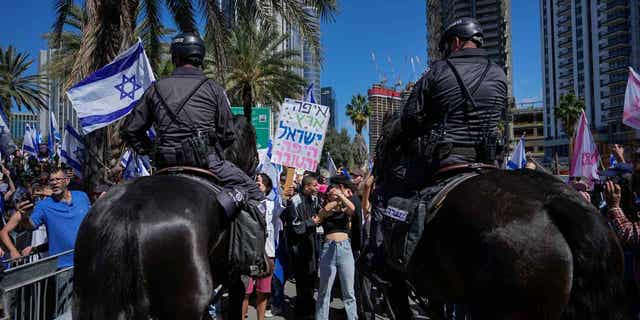 Mounted police are deployed as protestors block a main road to demonstrate against plans by Prime Minister Benjamin Netanyahu's new government to overhaul the judicial system in Tel Aviv, Israel, on March 9, 2023. 