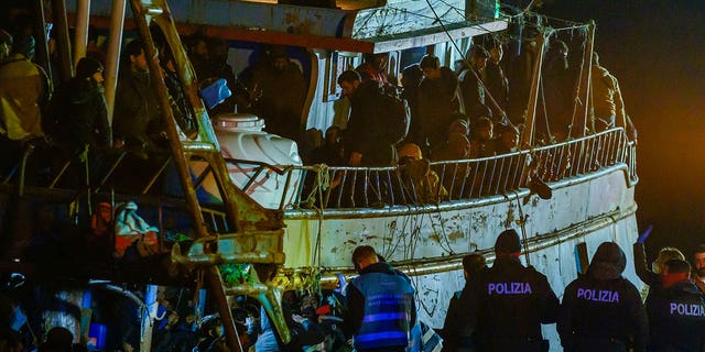 Police check a fishing boat carrying about 500 migrants in the southern Italian port of Crotone, on March 11, 2023. 