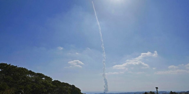 People watch as an H3 rocket is launched, at a field in Minamitane town in Kagoshima, southern Japan Tuesday, March 7, 2023. 