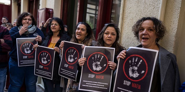 State-employed archaeologists in Greece hold placards in a strike action outside the Culture Ministry in Athens, on March 14, 2023, to protest the assault of an archaeologist on the island of Mykonos.