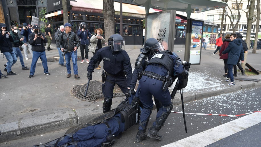 Riot police drag their fainted colleague