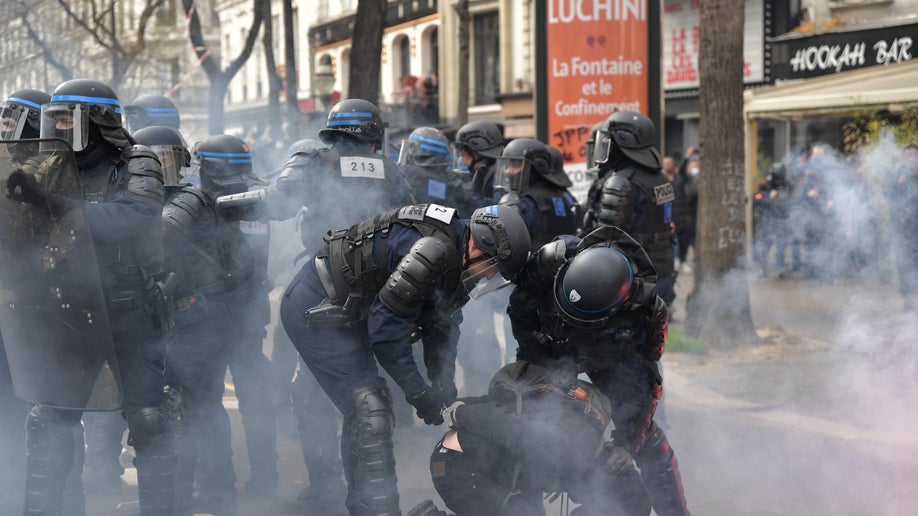 Riot police arrest a protester