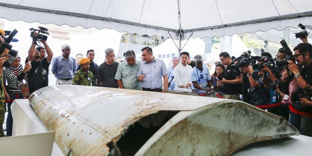 Malaysian Minister of Transport Anthony Loke, center, looks at a wing flap found on Pemba Island, Tanzania, which has been identified as a missing part of Malaysia Airlines Flight MH370 through unique part numbers traced to 9M-MRO during a commemoration event to mark the fifth anniversary of the missing Malaysia Airlines MH370 flight in Kuala Lumpur, Malaysia, March 3, 2019. 