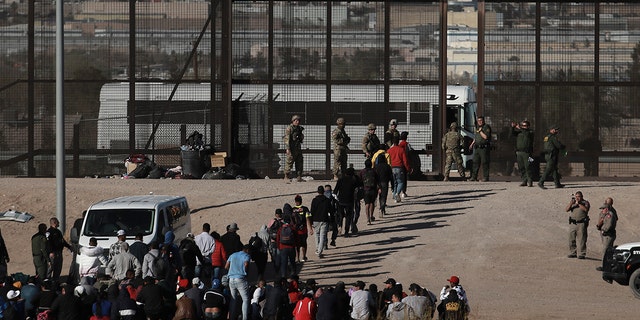 Migrants walk into U.S. custody after crossing the border from Ciudad Juarez, Mexico, on March 29, 2023. A day earlier, dozens of migrants died in a fire at a migrant detention center in Ciudad Juarez.