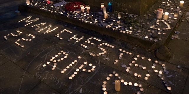 Memorial candles are seen during a vigil on St Ann's Square in Manchester, northwest England on May 29, 2017, exactly one week after a bomb attack at Manchester Arena killed 22 and injured dozens more. The attack, which has been claimed by an Islamic State jihadist group, targeted concertgoers at the end of a show by U.S. teen pop idol Ariana Grande.  