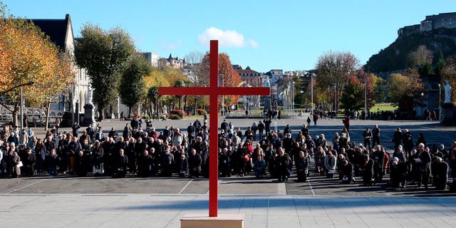 Bishops kneel on the forecourt of the Notre-Dame-du-Rosaire basilica in the sanctuary of Lourdes, southwestern France, on Nov. 6, 2021 during a ceremony, part of The Bishops' Conference.