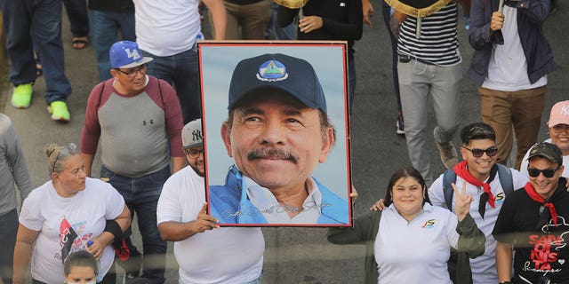 A man holds a portrait of President Daniel Ortega during a pro-government march in Managua, Nicaragua, on Feb. 11, 2023. Ortega executed 40 people, according to a United Nations human rights group.