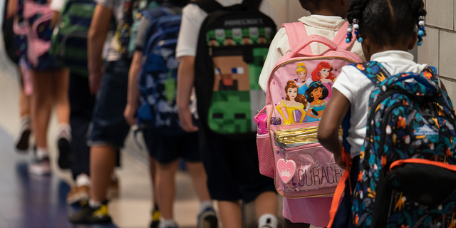 Students line up to enter their respective classrooms.