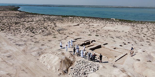 People look at ruins on Siniyah Island in Umm al-Quwain, United Arab Emirates, on March 20, 2023. Archeologists said Monday that they have found the oldest pearling town in the Persian Gulf on the island.