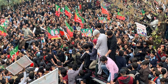 Supporters rally around a car carrying Pakistan's former Prime Minister Imran Khan (not pictured) after he appeared at the court on Feb. 28, 2023. 