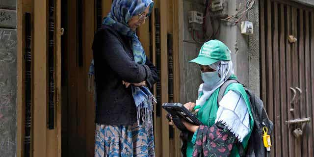 A government worker collects data from a woman during a census, in Lahore, Pakistan, on March 1, 2023. The country launched its first ever digital census in an effort to gather regional demographics prior to the upcoming elections.