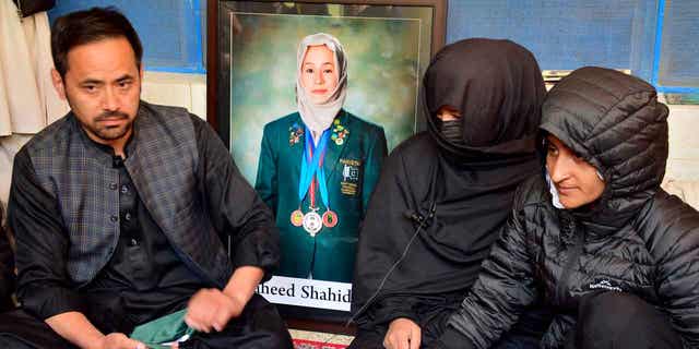 Sister Sadia Raza, center, relative Naimatullah Hazara, left, and friend Sumiaya Kianat, right, of Pakistani field hockey player Shahida Raza, who died in the shipwreck tragedy, attend her funeral, in Quetta, Pakistan, on March 17, 2023. 