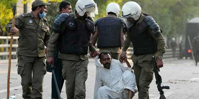 Police officers detain a supporter of Pakistan's former Prime Minister Imran Khan during a clash in Lahore, Pakistan, on March 8, 2023.