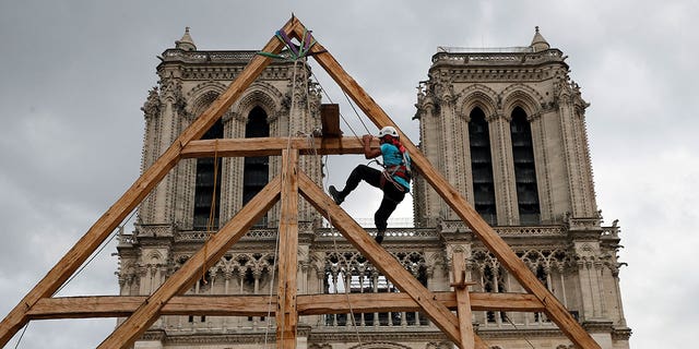 A carpenter works in front of the Notre Dame Cathedral in Paris, France, on Sept. 19, 2020. France's Notre Dame Cathedral's reconstruction is progressing enough to allow its reopening to the public at the end of next year.