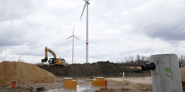 Wind turbines stand on a field in Budy Mszczonowskie, Poland, on Feb. 21, 2022.