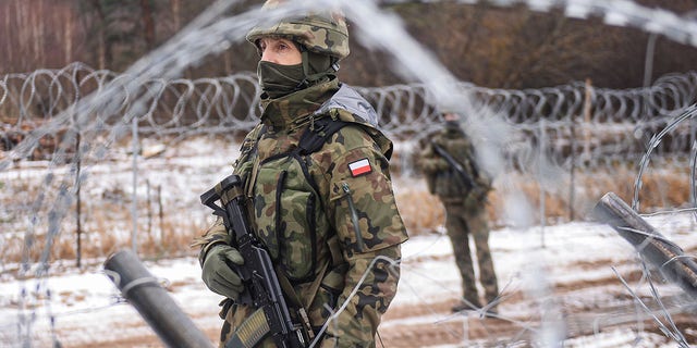 FILE: Polish army soldiers take part in a patrol by the barbed wire fence at the Polish Belarusian border during a media trip to the militarized area on January 13, 2022 in Kuznica, Poland. 