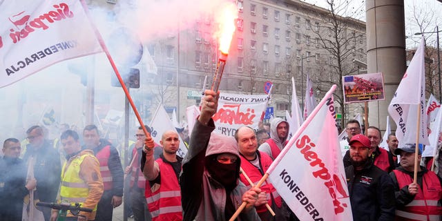 Some 300 Polish coal miners angered by the European Union directive reducing methane emissions protest noisily before the EU office saying it will deprive them of their jobs, in Warsaw, Poland, on March 24, 2023.