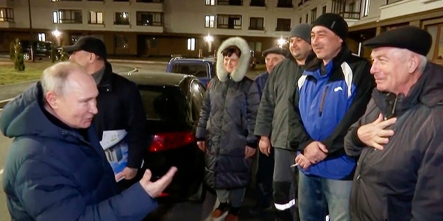 Russian President Vladimir Putin talks with local residents during his visit to Mariupol, Ukraine, over the weekend. A woman in this area was heard on video heckling Putin over the visit.