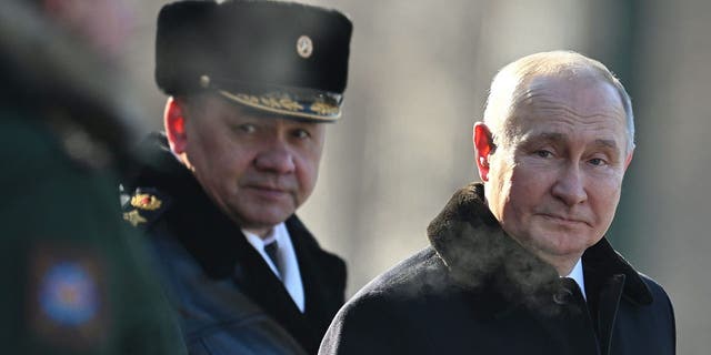 Russian President Vladimir Putin, right, and Russian Defence Minister Sergei Shoigu, left, attend a wreath-laying ceremony at the Eternal Flame and the Unknown Soldier's Grave in Alexander Garden during an event marking Defender of the Fatherland Day in Moscow.