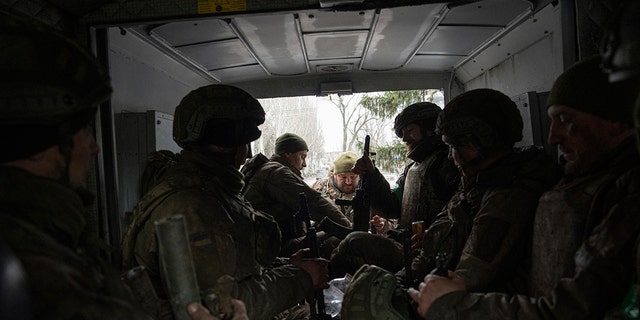 Ukrainian servicemen sit inside a van in Chasiv Yar, Ukraine, Wednesday, March 8, 2023. 