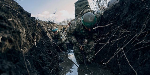 Ukrainian soldiers shelter in a trench during Russian shelling near Bakhmut, Ukraine, March 5, 2023.