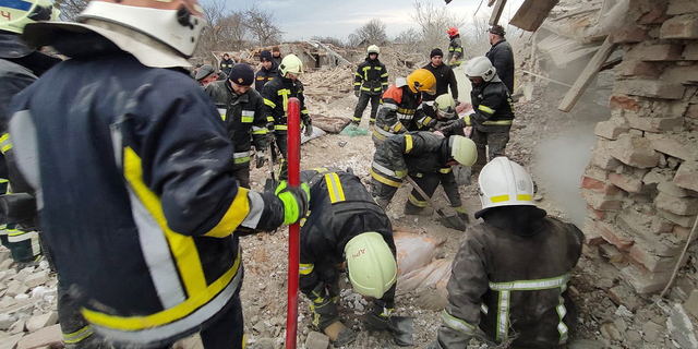 Rescuers sift through rubble of residential buildings in the Lviv region on March 9 that were destroyed by a Russian missile strikes.