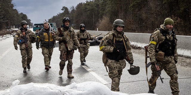 Members of the Ukrainian military arrive to reinforce a forward position on the eastern frontline near Kalynivka village on March 8, 2022, in Kyiv, Ukraine.