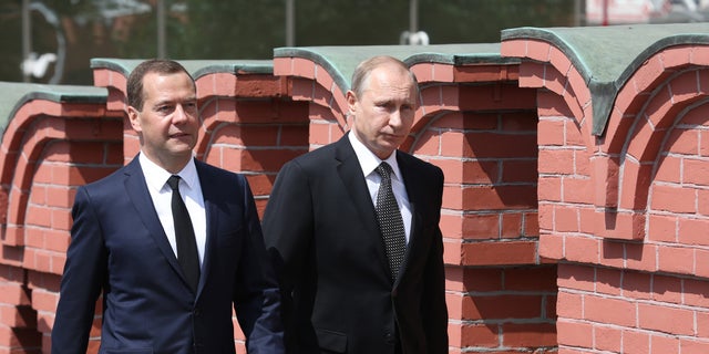 FILE PHOTO: Russian President Vladimir Putin, right, and Premier Dmitry Medvedev, walk along Moscow's Kremlin wall in June 2015. 
