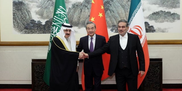 Iran's top security official, Ali Shamkhani, right, Chinese Foreign Minister Wang Yi, center, and Musaid Al Aiban, Saudi Arabia's national security adviser, shake hands after Iran and Saudi Arabia agreed to resume bilateral diplomatic ties in Beijing on March 10, 2023.