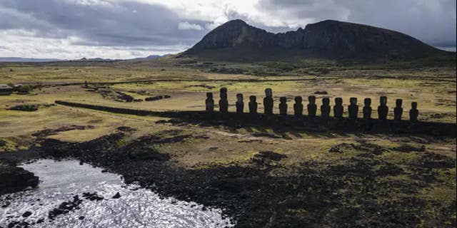 Moai statues stand on Ahu Tongariki near the Rano Raraku volcano, top, on Rapa Nui, or Easter Island, Chile, Nov. 27, 2022. According to Salvador Atan Hito, vice president of the Ma'u Henua Indigenous community which administers the archaeological treasure of Rapa Nui, on March 1, 2023, a small moai was discovered recently in the middle of a dry lagoon inside the volcano's crater. 