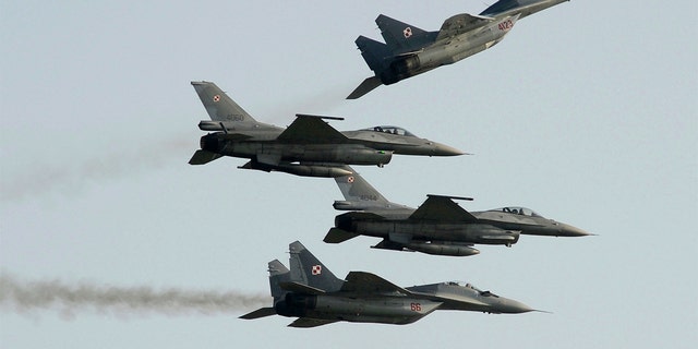 FILE PHOTO: Two Polish Air Force Russian made MiG-29s fly above and below two Polish Air Force U.S. made F-16 fighter jets during an air show in Radom, Poland.