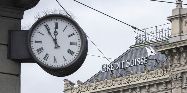 Five to twelve "fuenf vor zwoelf" is written on a clock next to a logo of the Swiss bank Credit Suisse, in Zurich, Switzerland, on March 20, 2023.