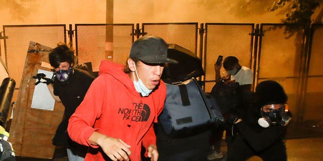 Demonstrators back away from tear gas during a Black Lives Matter protest on July 23, 2020, in Portland, Oregon.